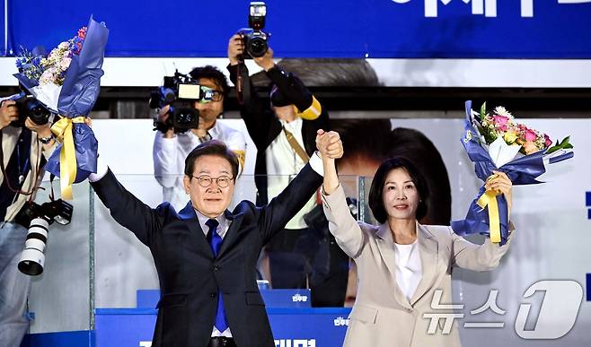 이재명 더불어민주당 대통령 후보와 부인 김혜경 여사가 4일 오전 당선이 확실시되자 서울 여의도 국회 앞을 찾아 꽃다발을 받아 들어보이고 있다. (공동취재) 2025.6.4/뉴스1 ⓒ News1 안은나 기자