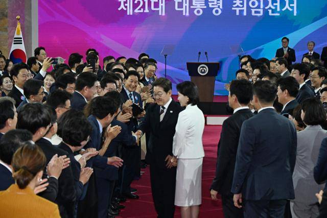 이재명 대통령이 4일 제21대 대통령 취임선서를 위해 김혜경 여사와 국회 로텐더홀에 입장하며 참석자들과 인사를 나누고 있다. 뉴스1