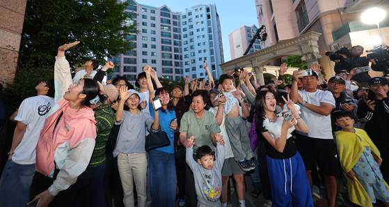 제21대 대통령 선거일인 3일 오후 더불어민주당 이재명 후보의 자택인 인천 계양구 아파트에서 주민들이 핸드폰으로 방송사 출구조사 결과를 보며 환호하고 있다. 연합뉴스