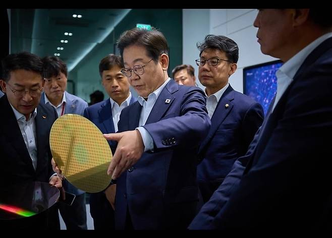 이재명 대통령이 후보 시절인 4월 28일 SK하이닉스 이천캠퍼스에서 반도체 웨이퍼를 살펴보고 있다. 곽노정 SK하이닉스 사장은 이날 이 대통령에게 반도체산업 지원의 필요성에 관해 설명했다. 사진=이재명 SNS 캡처