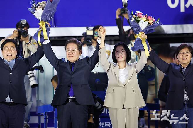 제21대 대통령 당선이 확실시되는 더불어민주당 이재명 대선 후보와 김혜경 여사가 4일 서울 여의도 국회 앞에 마련된 더불어민주당 국민 개표방송 행사에서 꽃다발을 받은 뒤 인사하고 있다. 류영주 기자