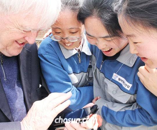 2015년 발달장애인 40여명이 일하는 사회적기업‘엠마우스산업’직원들에게 스마폰으로 촬영한 사진을 보여주며 즐거워하는 천노엘 신부. /김한수 기자