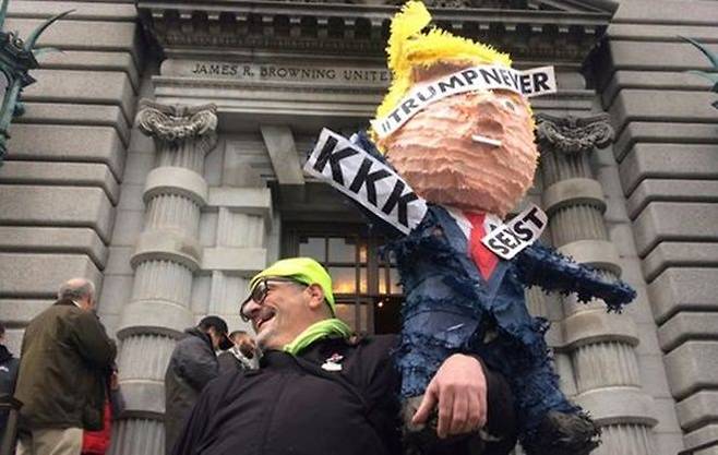 지난 2017년 2월9일 도널드 트럼프 1기 장부 당시 미 샌프란시스코의 제8 순회 항소법원 앞에서 한 시위자가 트럼프 인형을 들고 그의 이슬람국가 국민들 입국 금지령에 항의 시위를 벌이고 있다. ⓒ AP/뉴시스