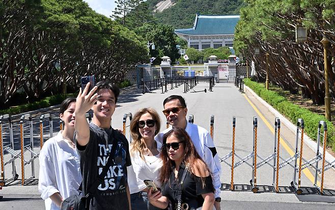 Visitors take photos in front of Cheong Wa Dae, the former presidential office and residence, in Jung-gu, Seoul, Wednesday. (Im Se-jun/The Korea Herald)