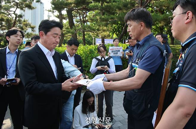 강훈식 대통령비서실장이 6일 서울 용산 대통령실 청사 인근 전쟁기념관 앞에서 태안화력발전소 사고 희생자 고(故) 김충현 씨와 관련해 엄길용 공공운수노조 위원장, 유족, 사고 대책위 관계자로부터 요구 서한을 받고 있다. 대통령실사진기자단