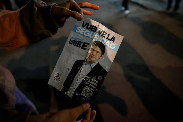 한 시민이 콜롬비아 보고타에서 7일 괴한에 의해 총격을 당한 미겔 우리베 투르베이 콜롬비아 상원의원의 유세 전단지를 들어보이고 있다. 보고타=로이터 연합뉴스