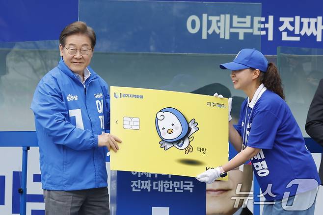 이재명 대통령이 후보자 시절 경기지역화폐(파주페이) 판넬을 전달받고 있다. ⓒ News1 안은나 기자