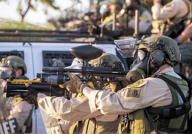 7일 미국 LA 콤프턴 지역에서 무장한 정부 요원들이 시위대와 대치하고 있다. /AFP 연합뉴스