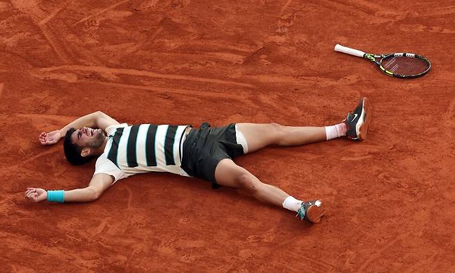 카를로스 알카라스(스페인)가 8일(현지시각) 프랑스 파리의 롤랑가로스에서 열린 프랑스오픈 테니스 남자단식 결승전에서 세계 1위 얀니크 신네르(이탈리아)를 5세트 접전 끝에 꺾은 뒤 클레이코트 위에 누워 있다. 파리/UPI 연합뉴스