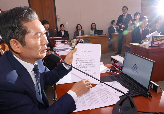 지난달 14일 국회에서 열린 법제사법위원회 전체회의에서 더불어민주당 소속 정청래 법사위원장이 대법관들의 불출석 사유서를 보여주고 있다. 연합뉴스