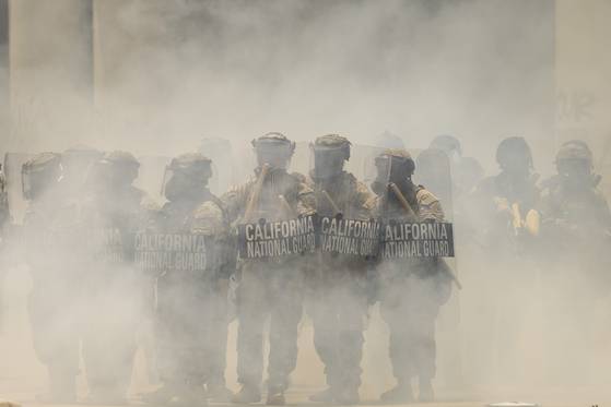 8일 미국 캘리포니아주 로스앤젤레스의 에드워드 R. 로이벌 연방청사 앞에서 최루가스 연기 너머로 보이는 캘리포니아 주방위군 대원들. EPA=연합뉴스