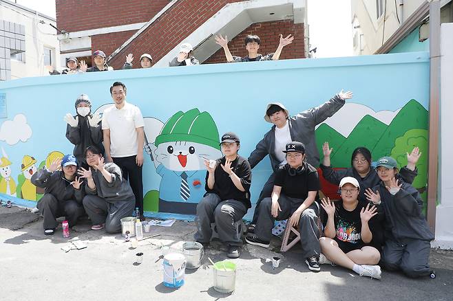박재윤 학과장과 학생들이 벽화그리기를 마치고 기념사진을 촬영하고 있다