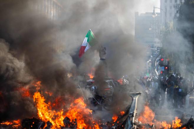 8일(현지시간) 미국 캘리포니아주 로스앤젤레스(LA)에서 한 남성이 자동차 위에 서서 멕시코 국기를 흔들고 있다. 도널드 트럼프 대통령의 행정부가 LA에서 일련의 불법 이민자 단속에 나서면서 이틀 동안 경찰, 주방위군과 시위대 사이 물리적 충돌이 이어졌다. /AFPBBNews=뉴스1