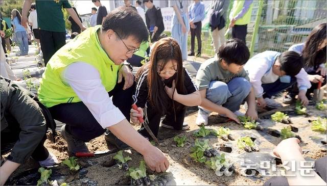 이정환 전북농협본부장(맨 왼쪽)이 전주동초등학교 내 스쿨팜에서 학생들에게 상추 모종 심는 법을 가르쳐주고 있다.