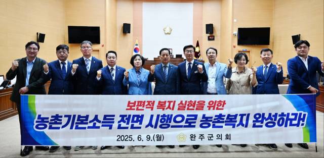 ▲9일 완주군의회 의원들이 본회의장에서 '농촌기본소득 전면 시행으로 농촌복지 완성하라!'는 내용의 현수막을 들고 기본소득 정책 실현을 촉구하고 있다. ⓒ완주군의회