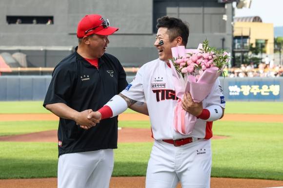 KIA 타이거즈 최형우가 지난 7일 광주 기아챔피언스필드에서 열린 2025 KBO리그 정규시즌 한화 이글스와의 홈 경기를 앞두고 개인 400홈런을 기념해 이범호 감독에게 꽃다발을 받고 있다. KIA 타이거즈 제공