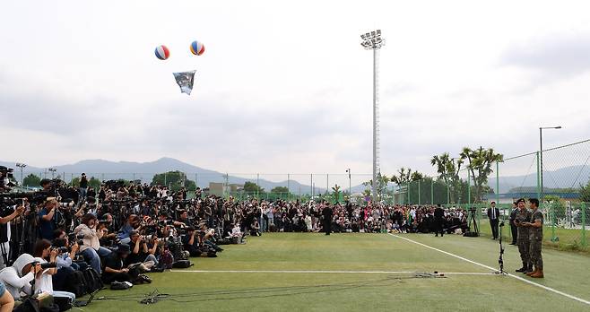 BTS members RM and V greet fans near a military base in Chuncheon, Gangwon Province after completing their military service on June 10. /Newsis