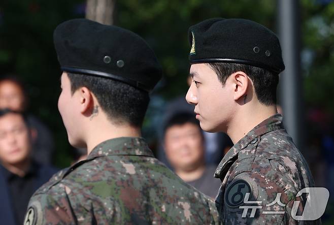 방탄소년단(BTS)의 정국 지민(오른쪽)이 11일 오전 경기도 연천군 연천공설운동장에서 군 복무를 마친 뒤 군복무를 마친 뒤 전역 인사를 하고 있다. ⓒ News1 권현진 기자