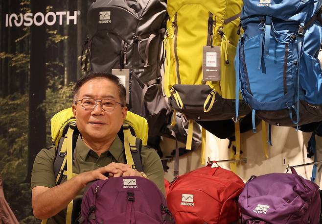 정인수 동인기연 대표가 자체 브랜드 아웃도어 배낭을 메고 있다. 이충우 기자