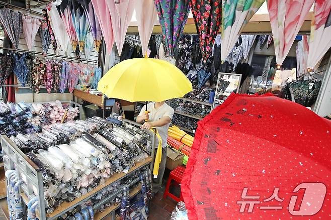 제주에서 올해 첫 장마가 시작된 12일 오후 대구 중구 서문시장의 한 우산가게에서 주인이 우산을 꺼내 진열하고 있다. 평년보다 1주일 빠른 올해 장마는 13일 오후부터 대구·경북에도 비를 뿌릴 전망이다. 2025.6.12/뉴스1 ⓒ News1 공정식 기자