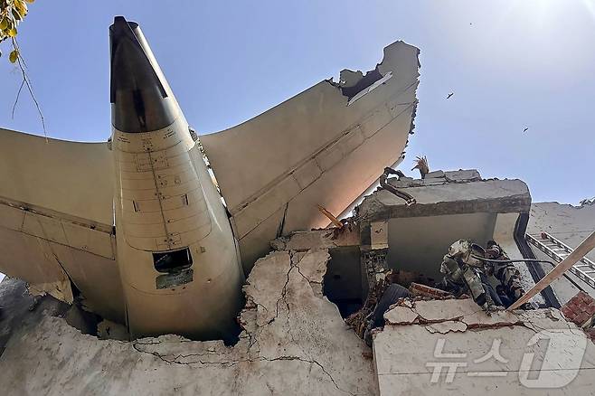 12일(현지시간) 242명을 태우고 인도 서부 아메다바드 공항 근처에서 추락한 인도 국영항공사 에어인디아 171편 여객기의 꼬리 부분이 건물에 처박혀 있다. 2025.6.12 ⓒ AFP=뉴스1