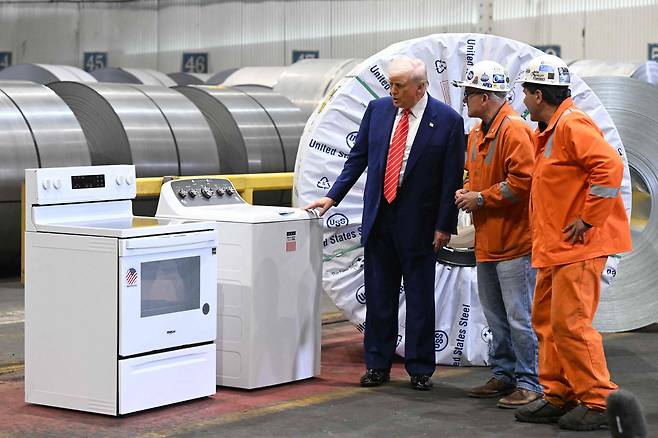 도널드 트럼프 미국 대통령(왼쪽)이 지난달 펜실베니아주 웨스트미플린에서 US스틸 공장을 견학하면서 파트너십을 기념하는 세탁기를 바라보고 있다. /연합뉴스