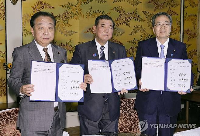 일본 집권 자민당 총재인 이시바 시게루 총리(가운데)와 연립 여당 공명당 사이토 데쓰오 대표(오른쪽), 제1야당 입헌민주당 노다 요시히코 대표가 지난 27일 연금 제도 개편에 합의한 후 서명한 문서를 들어 보이고 있다. 사진 교도=연합뉴스