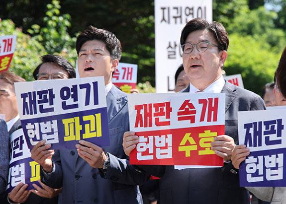 국민의힘 김용태 비상대책위원장(왼쪽)과 권성동 전 원내대표가 6월 11일 서울 서초구 서울고법 앞에서 재판부의 기일 추후 지정 결정을 비판하는 의원총회를 열고 구호를 외치고 있다. 뉴시스