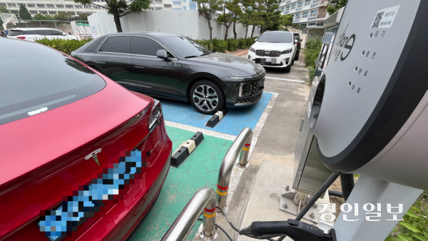 지난 13일 오전 11시께 인천 중구 한 중학교 주차장에 설치된 전기차 충전기가 작동을 멈춰 충전 구역에 주차된 전기차가 충전을 하지 못하고 주차돼있다. 2025.6.13 /정선아기자 sun@kyeongin.com