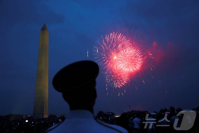 14일(현지시간) 미국 워싱턴DC에서 열린 미 육군 창설 250주년 기념 열병식 참석 군인이 워싱턴 모뉴먼트 근처에서 터지는 붗꽃을 바라보고 있다. 2025.06.14 ⓒ 로이터=뉴스1 ⓒ News1 류정민 특파원