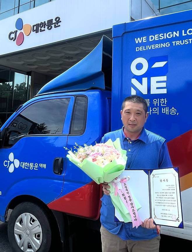 CJ대한통운 택배기사 송종현씨가 시민 구조에 기여한 공로로 감사장을 받고 기념촬영을 하고 있다.ⓒCJ대한통운