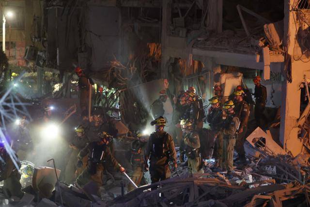 이스라엘 구조대원들이 15일 이스라엘 남부 도시 바트얌 지역에서 이란 탄도미사일에 피격 된 건물 잔해를 살펴보고 있다. 바트얌=AFP 연합뉴스