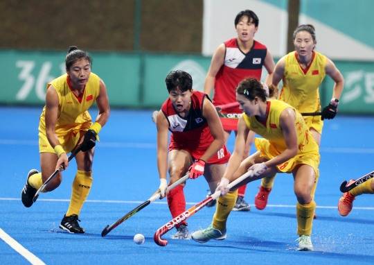 국내 전국대회에서 여자 하키 선수들이 스쿱 동작으로 볼을 다루는 모습.
