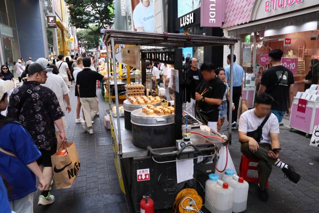 소상공인과 자영업자들이 불황의 직격탄을 맞고 있는 가운데 서울 명동 거리에 노점상들이 늘어서 있다. 연합뉴스