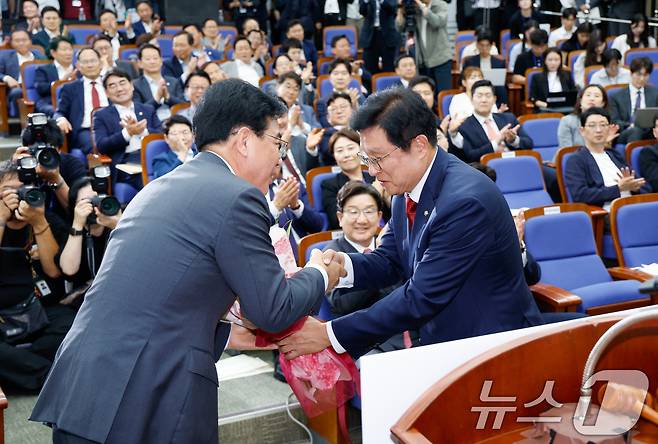 국민의힘 신임 원내대표로 선출된 송언석 의원(왼쪽)이 16일 오후 서울 여의도 국회에서 열린 의원총회에서 박형수 선관위원장으로부터 꽃다발을 받고 있다. 2025.6.16/뉴스1 ⓒ News1 안은나 기자