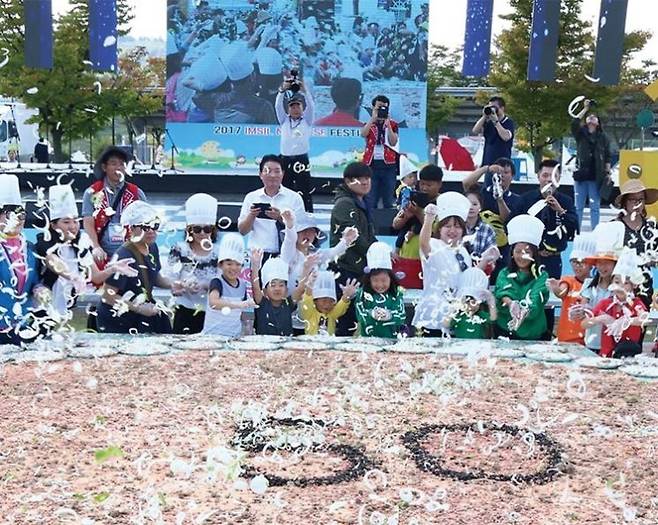 임실N치즈축제를 찾은 방문객들이 치즈를 이용한 대형 쌀피자 만들기 체험을 하고 있다. 임실군청