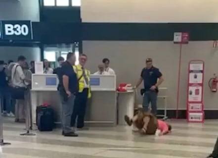 지난 8일 이탈리아 밀라노의 한 공항에서 바닥에 누워 항의하는 여성./ 뉴욕포스트