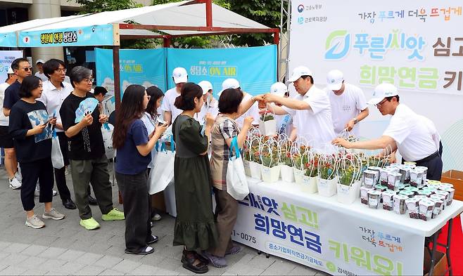 근로복지공단은 13일 서울 구로구 구로동 구로디지털단지역 인근에서 중소기업 퇴직연금 기금인 '푸른씨앗'을 홍보하는 꽃 화분과 씨앗 키트 나눔 행사를 진행했다. /근로복지공단