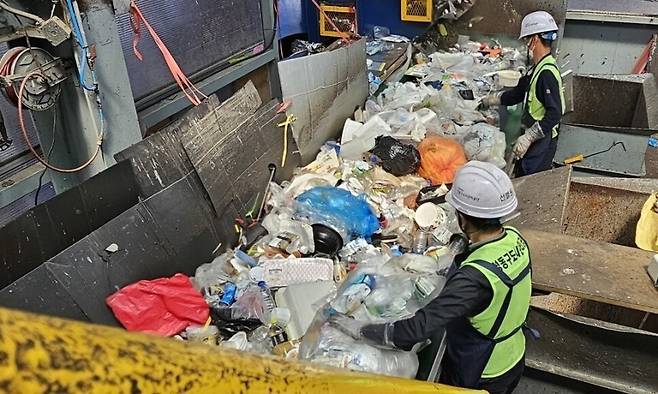 지난해 8월 서울 성동구 관내 상가와 단독주택 등에서 재활용 가능 자원으로 분리배출한 폐기물들이 선별을 위해 컨베이어벨트에 실려 이동하는 모습. 광학 선별기, 비닐형상 선별기 등이 동원되지만 자동 선별의 정확도가 높지 않아 주요 선별 단계마다 작업조가 배치돼 있다. 김정수 선임기자 jskim24@hani.co.kr