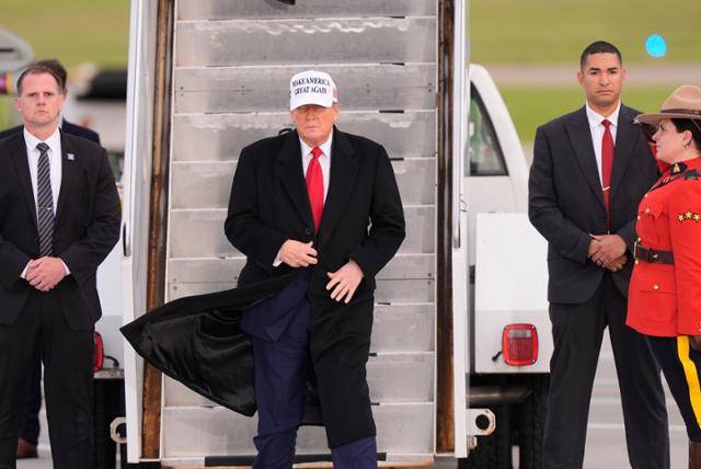 도널드 트럼프(왼쪽 두 번째) 미국 대통령이 15일 캐나다 캘거리 국제공항에 도착해 전용기에서 내리고 있다. 캘거리=AP 연합뉴스