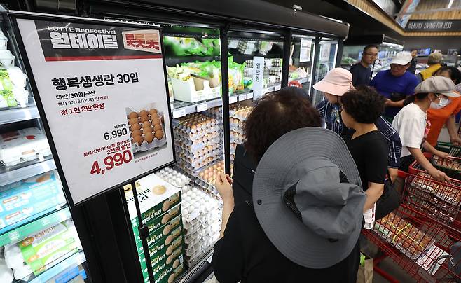 지난 12일 서울 동대문구 롯데마트 청량리점에서 시민들이 계란을 고르고 있다. 이날 롯데마트는 계란 한 판을 4990원에 파는 특가 행사를 진행했다. 연합뉴스