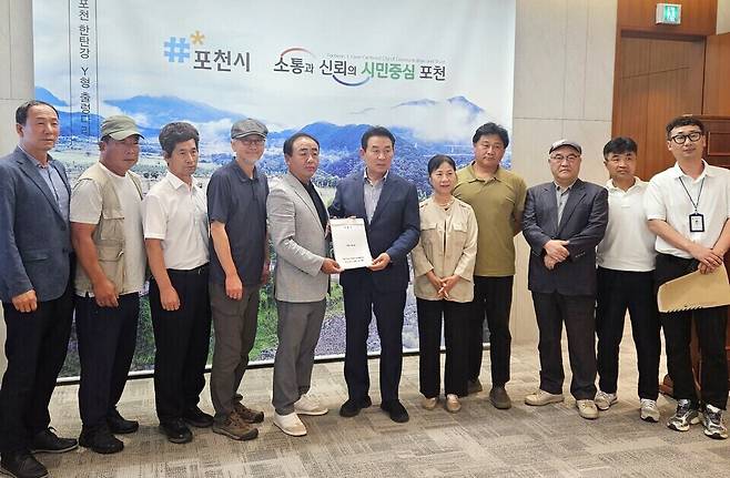 ▲ 포천시 내촌면 주민들이 지난 16일 베어스타운 장기 휴장으로 인한 지역경제 피해를 호소하며 주민 1200여 명의 서명을 담은 탄원서를 시에 제출하고 있다. /사진제공=포천시
