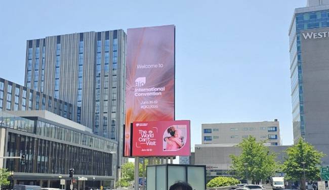 16일(현지시간) 미국 보스턴 컨벤션앤드엑시비션센터 입구 대형 스크린에 이번 바이오 USA 주제인 'The World Can't Wait'라는 문구가 소개되고 있다./사진=비즈워치