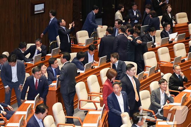 더불어민주당 의원들이 5일 오후 서울 여의도 국회 본회의장에서 기념 촬영하는 가운데 국민의힘 의원들이 입장하고 있다. 2025.6.5/뉴스1 ⓒ News1 안은나 기자