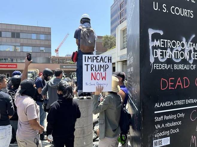 미국 로스앤젤레스(LA) 도심의 연방 구금시설인 '메트로폴리탄 디텐션 센터'(Metropolitan Detention Center) 앞에서 시위 중인 사람들. 이들은 미 이민세관단속국(ICE)의 대대적인 불법 이민자 단속에 반발하는 시위를 벌이고 있다. 사진=연합뉴스