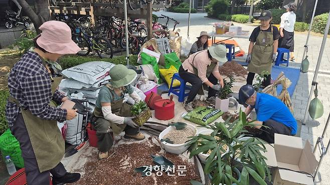 서울 동대문구 래미안 미드카운티 아파트에서 18일 진행된 서울시 ‘찾아가는 반려식물 클리닉’에서 직원들이 주민들의 화분을 처방전에 맞춰 분갈이 하고 있다. 류인하 기자