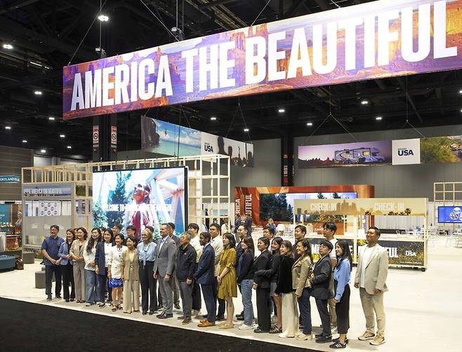 한국 참가자들이 미국관광청(Brand USA) 부스 앞에서 기념촬영을 하고 있다