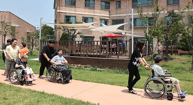 ▲ 19일 오전 양주시 연곡리 중증장애인거주시설 '요셉의집' 정원에서 점심 식사를 마친 이용인들이 사회복지사들의 도움으로 휠체어를 타고 산책하고 있다. /김철빈 기자 narodo@incheonilbo.com