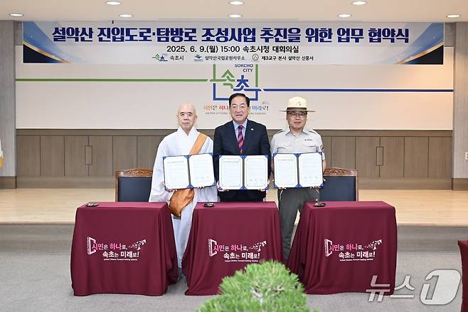 지난 9일 오후 강원 속초시청 대회의실에서 열린 설악산 '진입도로·탐방로 조성을 위한 관계기관 협약식'에서 이병선 시장(사진 가운데)과 대한불교 조계종 제3교구 본사 신흥사 주지 스님(사진 왼쪽), 현병관 국립공원공단 설악산사무소장이 협약서를 들고 기념촬영을 하고 있다.(속초시 제공, 재판매 및 DB 금지)