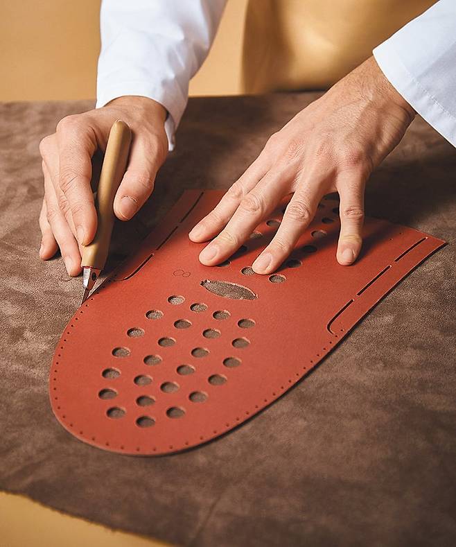 장인의 손으로 직접 품질을 확인 하며 레더를 컷팅 하고 있는 모습. /토즈 그룹 제공